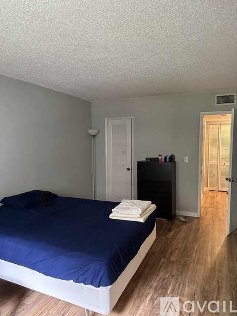 A bedroom with a bed, dresser, and closet.