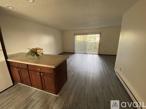A room with a marble countertop and wooden cabinets.