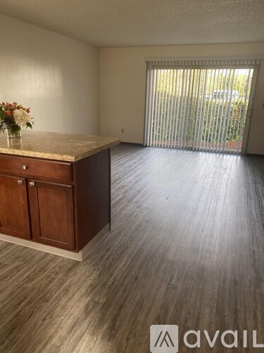 A room with a wooden cabinet and a marble top with a vase of flowers on it.