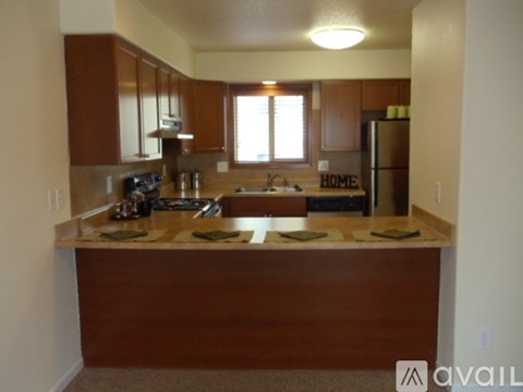 A kitchen with brown cabinets and a brown island.