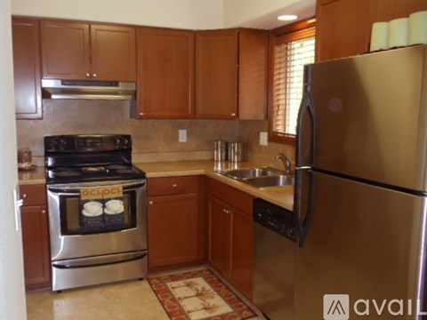 A kitchen with a refrigerator, oven, and sink.