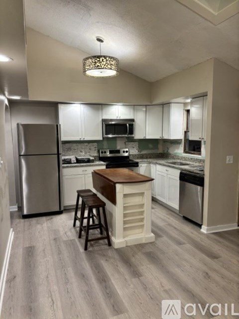 A kitchen with a refrigerator, microwave, and oven.