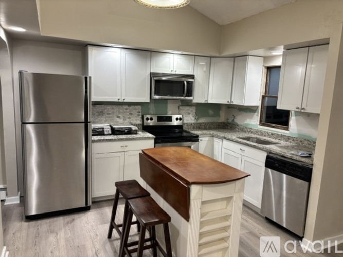 A kitchen with a refrigerator, stove, and microwave.