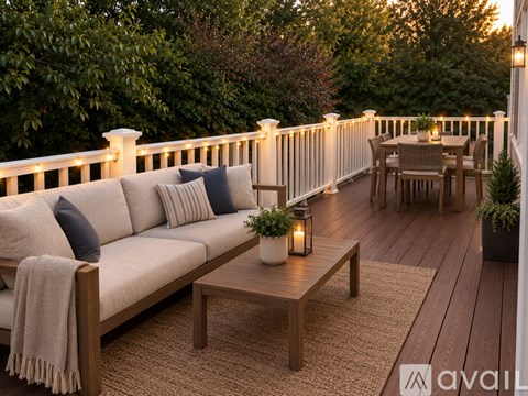 A patio with a couch, table, and chairs is set up for a cozy evening.