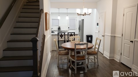 A dining room with a wooden table and chairs.