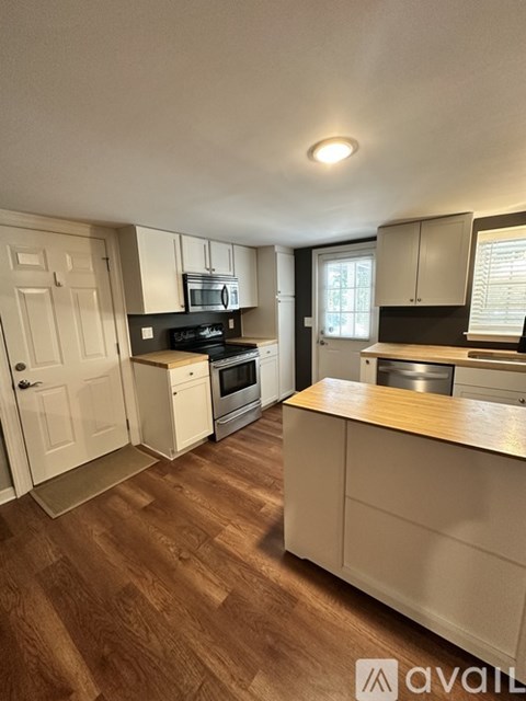 A kitchen with wooden floors and white walls.