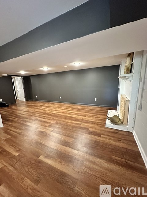 A room with wooden flooring and a white wall.