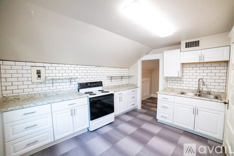 A kitchen with white cabinets and a black stove top oven.