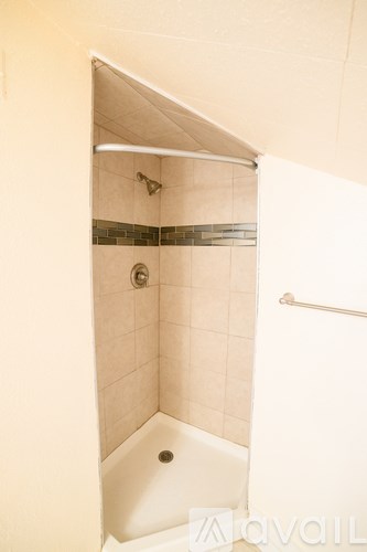 A white bathroom with a shower and a white tub.