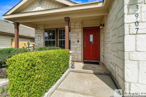 A house with a red door and a number 3907 on the wall.