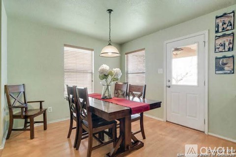 A dining room with a table set for four.