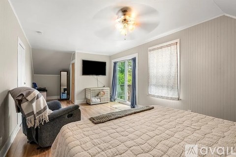 A bedroom with a large bed and a flat screen TV mounted on the wall.