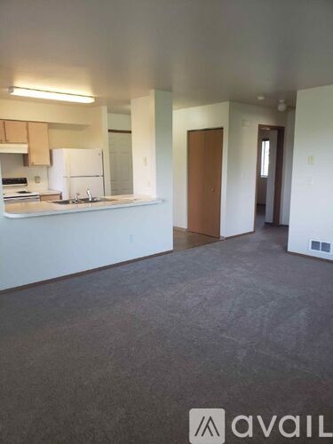 A kitchen area with a white fridge and a sink.
