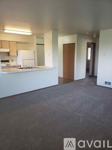 A kitchen area with a white fridge and a sink.