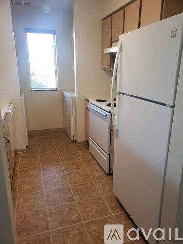 A kitchen with a white fridge, dishwasher and oven.