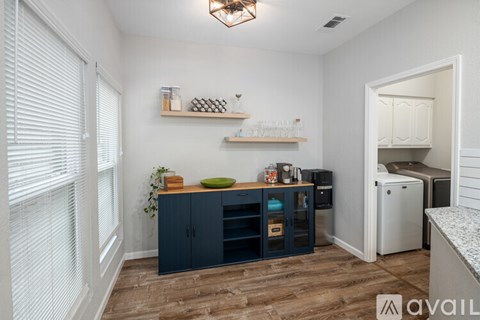 A kitchen with dark blue cabinets and a white refrigerator.