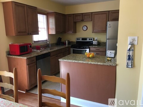 A kitchen with brown cabinets and a red microwave.