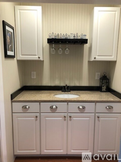 A kitchen with white cabinets and a granite countertop.