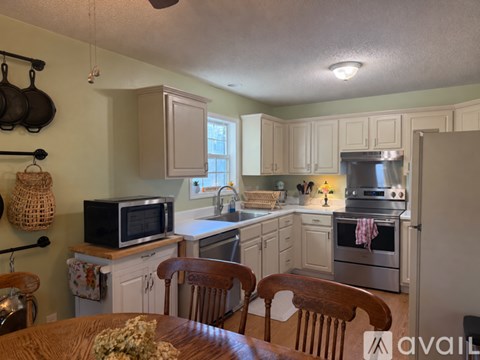 A kitchen with a table and chairs in front of it.