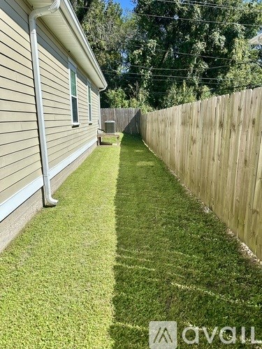 A house with a wooden fence and green grass.