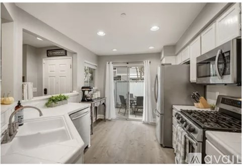 A modern kitchen with white appliances and a white sink.
