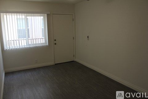A room with a door and a window with blinds.