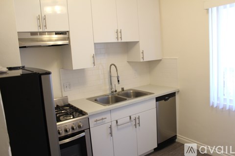 A kitchen with white cabinets and a black stove top oven.