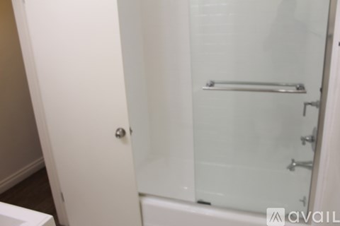 A white bathroom with a glass shower door.