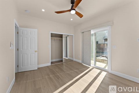 A spacious room with a ceiling fan and sliding glass doors.
