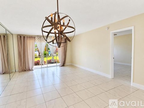 A large room with a chandelier and sliding glass doors.