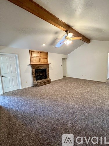 A room with a fireplace and a ceiling fan.