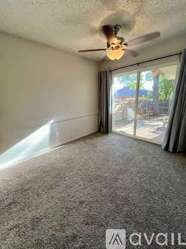 A room with a ceiling fan and carpeted floor.