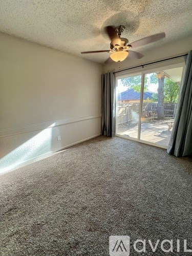 A room with a ceiling fan and carpeted floor.