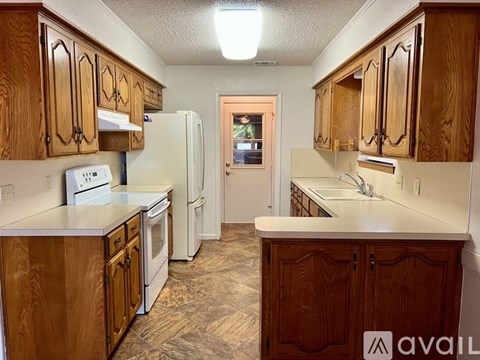 A kitchen with wooden cabinets and appliances.