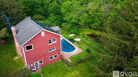 A red house with a pool in the backyard.