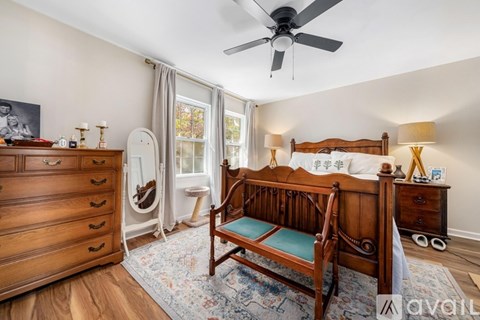 A bedroom with a bed, dresser, and window.