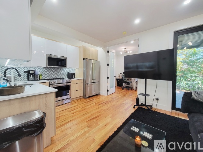 A modern kitchen with wooden floors and a large island.