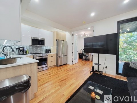 A modern kitchen with wooden floors and a large island.