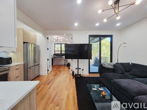 A modern living room with a black couch and a television.