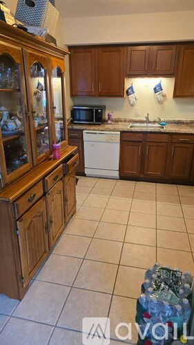 A kitchen with wooden cabinets and a white dishwasher.