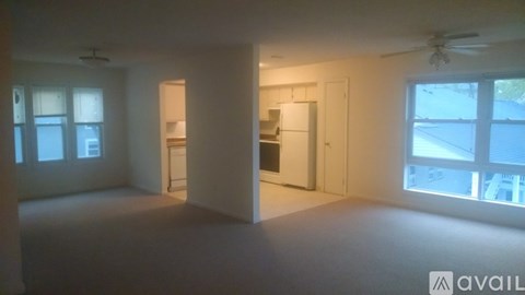 A spacious empty room with a window and a door.