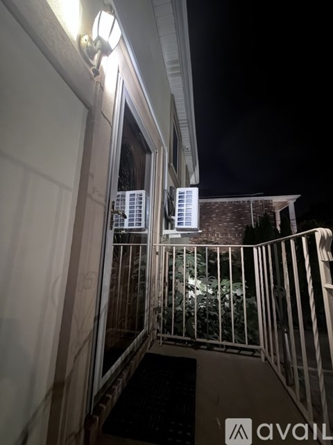 A balcony with a metal railing and a lit sign that reads "AVAILABLE".