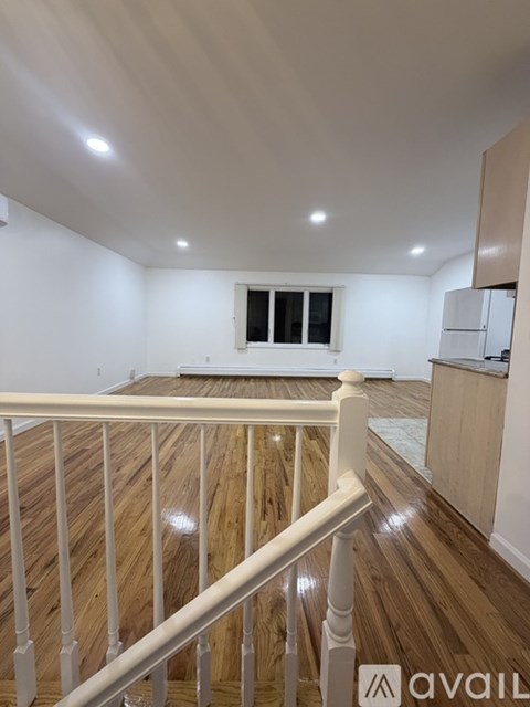 A room with a window and wooden stairs.