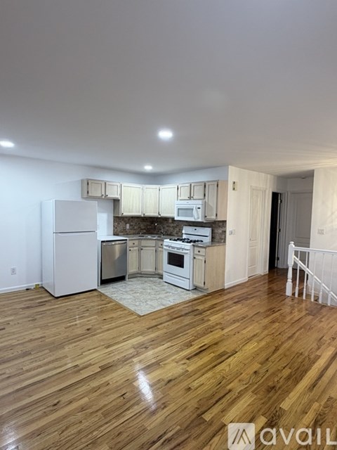 A kitchen with wooden floors and white appliances.