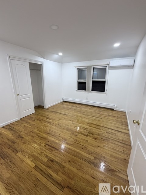 A room with wooden flooring and a window.
