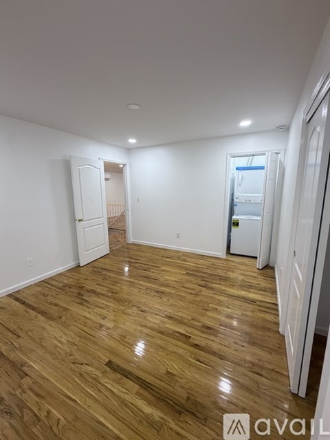 A room with wooden flooring and white walls.