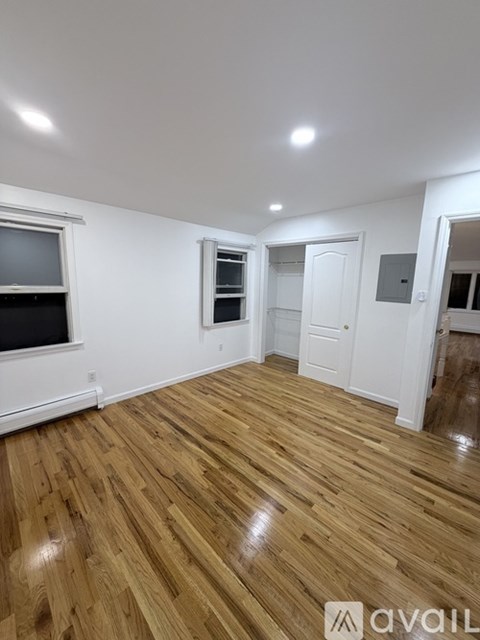 A room with wooden flooring and white walls.
