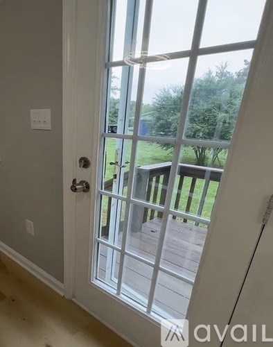 A door with a glass window and a handle is open.