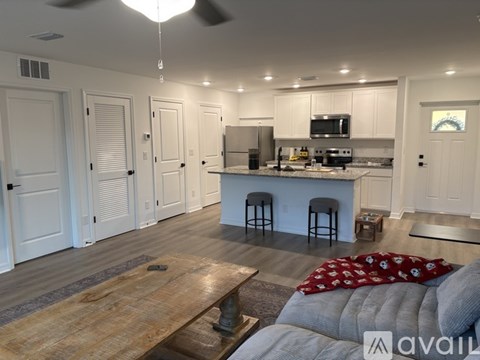 A modern kitchen with white cabinets and a wooden island.