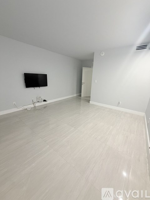 A spacious room with a flat screen TV mounted on the wall.